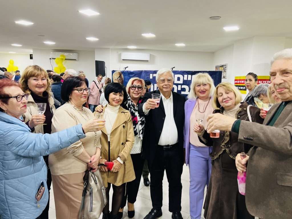 ראש העיר חיים צורי מרים כוסית לחיים, עם תושבים שבאו לאחל חג שמח